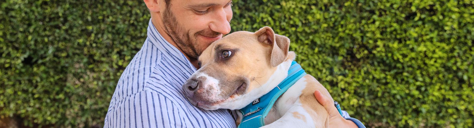Smiling person holding a dog in their arms